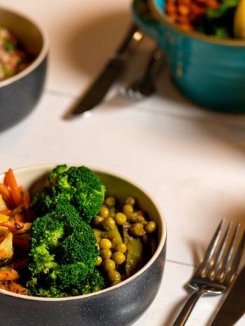Delicious colorful bowls of salad and fresh beverages on a white table, perfect for healthy dining.